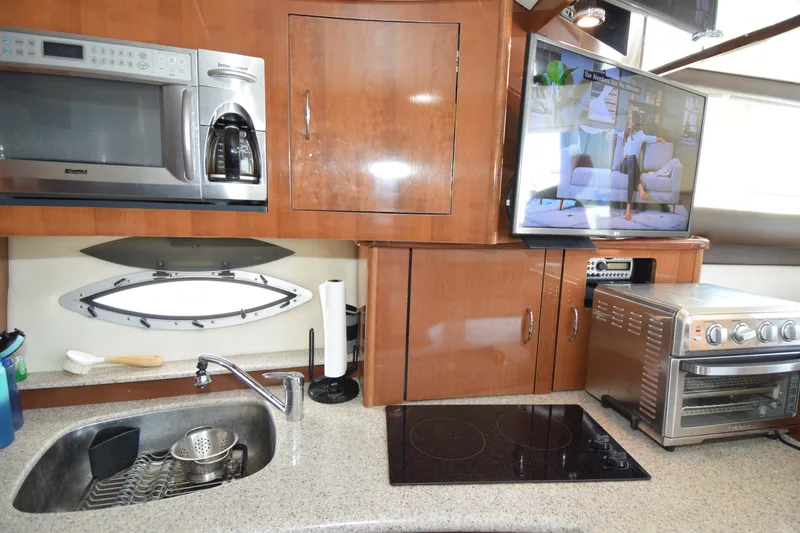 Slide: The Image of 2008 Carver 36 Mariner kitchen with microwave, sink, stove, and TV. - 8