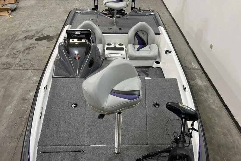 Slide: The Image of 2022 Bass Cat Bobcat boat interior with seating and control panel in a garage setting. - 16