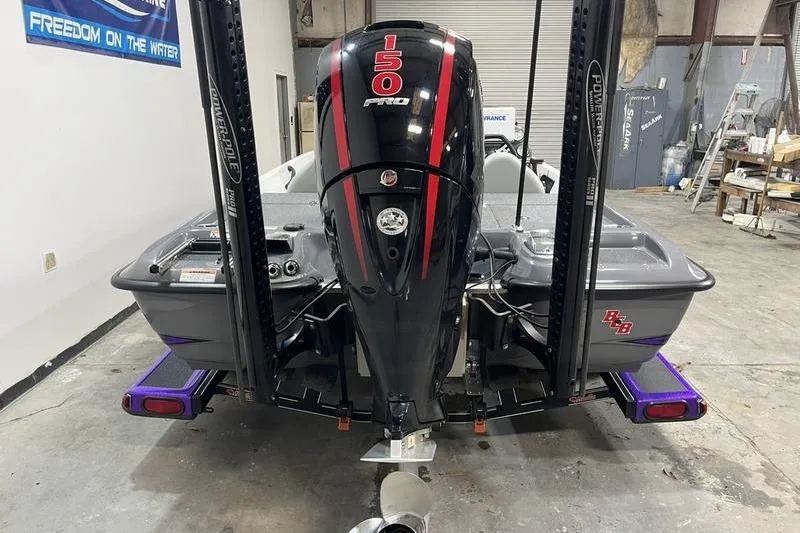 Slide: The Image of 2022 Bass Cat Bobcat boat with 150 Pro engine in a garage setting. - 4