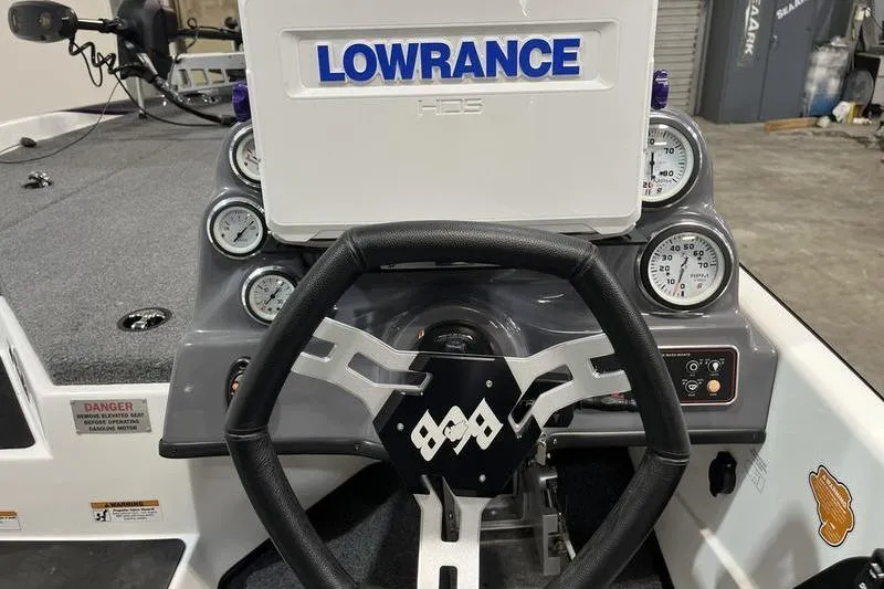 Slide: The Image of Bass Cat Bobcat 2022 boat dashboard with Lowrance HDS display and steering wheel. - 8