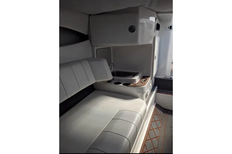 Slide: The Image of 2007 Sunsation 32 Dominator interior with white seating and compact kitchenette. - 10