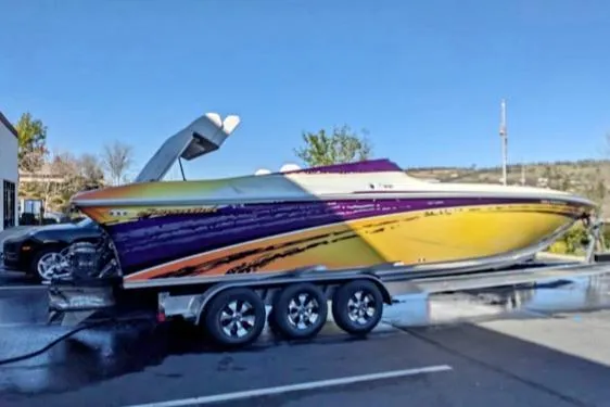 Slide: The Image of 2007 Sunsation 32 Dominator speedboat on trailer, vibrant yellow and purple design. - 3