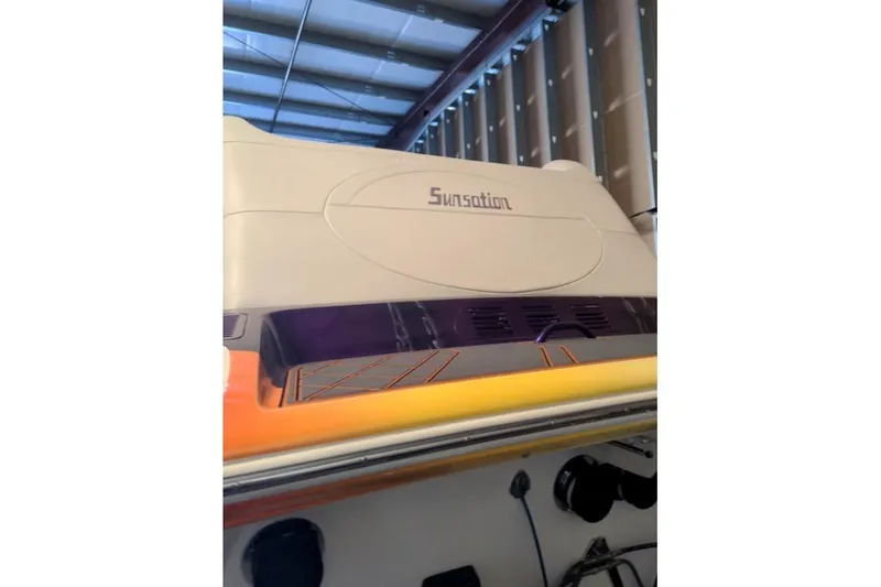 Slide: The Image of 2007 Sunsation 32 Dominator boat in storage, showcasing sleek design and vibrant colors. - 6