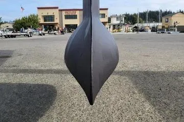 Slide: The Image of 2002 Jeanneau Sun Odyssey 43 DS keel, dry docked, with marina buildings in background. - 13