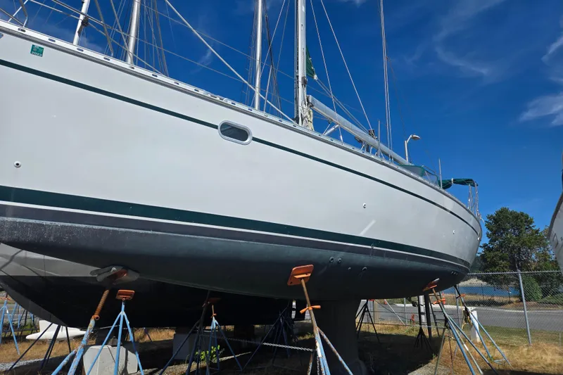 Slide: The Image of 2002 Jeanneau Sun Odyssey 43 DS sailboat on stands, clear blue sky background. - 2