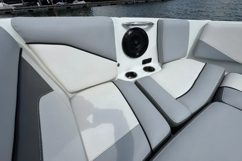 Slide: The Image of 2021 Supreme ZS232 boat interior with gray and white seating, speaker, and cup holders. - 12