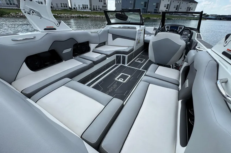 Slide: The Image of 2021 Supreme ZS232 boat interior with sleek gray and white seating, dockside view. - 23