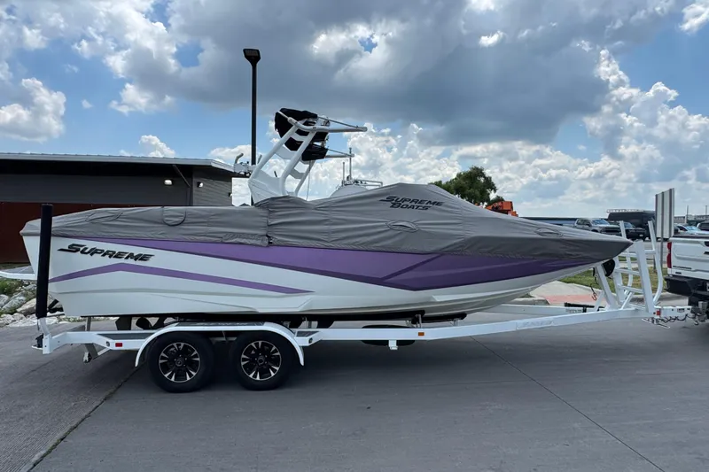 Slide: The Image of 2021 Supreme ZS232 boat on trailer, covered, with cloudy sky background. - 8
