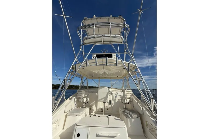 Slide: The Image of 2003 Pursuit 3000 Offshore boat with tower, on calm water under clear blue sky. - 10