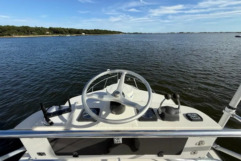 Slide: The Image of 2003 Pursuit 3000 Offshore boat helm with ocean view and clear blue sky. - 12