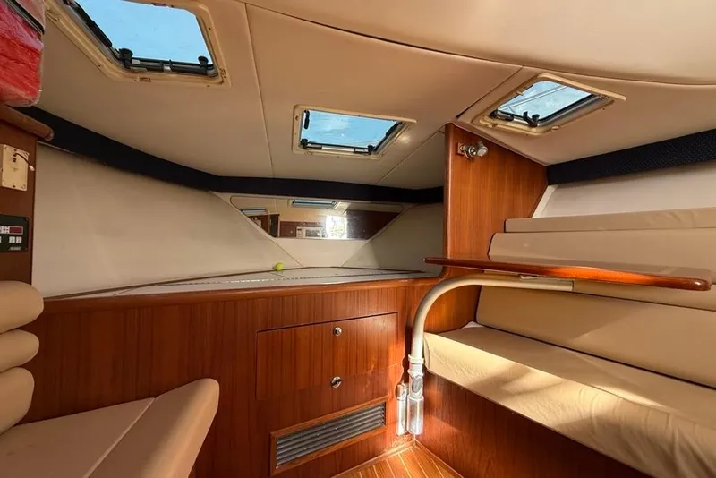 Slide: The Image of 2003 Pursuit 3000 Offshore cabin interior with wood finish and skylights. - 16