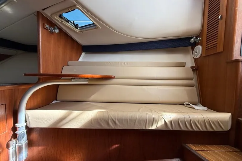 Slide: The Image of 2003 Pursuit 3000 Offshore cabin interior with beige seating and wooden accents. - 17