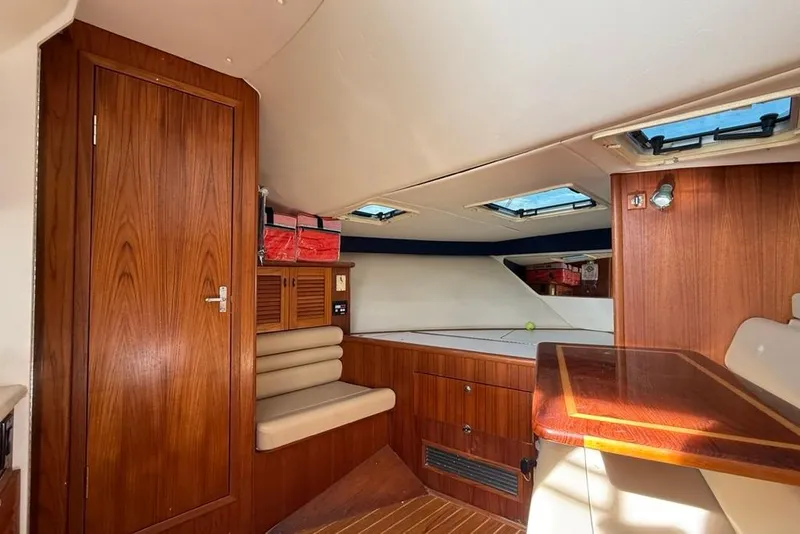 Slide: The Image of Interior of 2003 Pursuit 3000 Offshore boat with wood paneling and seating. - 18