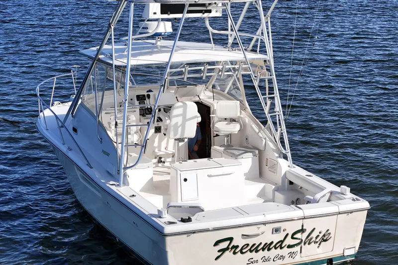 Slide: The Image of 2003 Pursuit 3000 Offshore boat on water, featuring spacious deck and fishing equipment. - 6