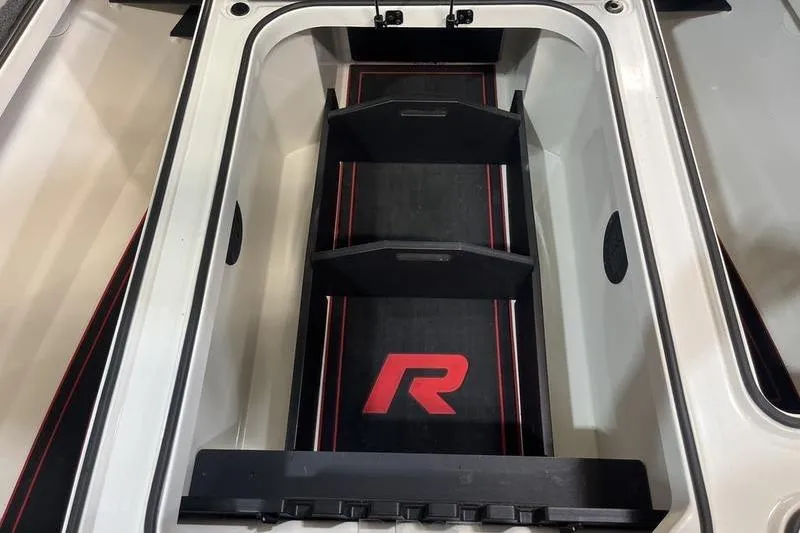 Slide: The Image of 2022 Ranger Z520R boat storage compartment with red logo and dividers. - 19