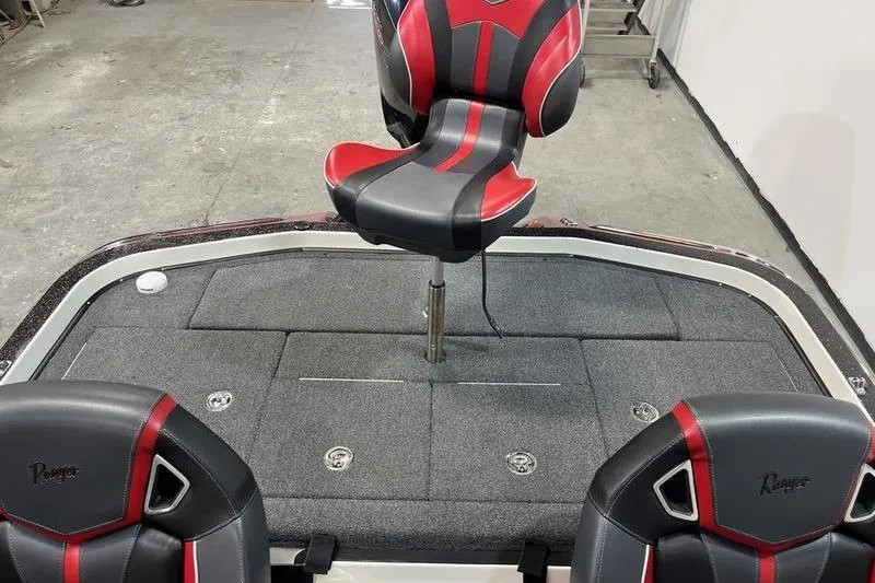 Slide: The Image of 2022 Ranger Z520R boat interior with red and black seats on a gray deck. - 5