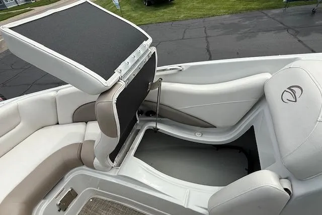 Slide: The Image of 2018 Crownline 255 SS boat interior with open storage compartment and cushioned seating. - 14