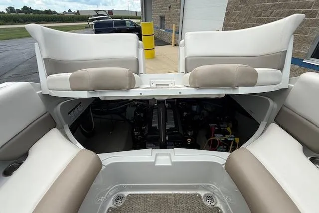 Slide: The Image of 2018 Crownline 255 SS boat interior with open engine compartment, showcasing seating and engine details. - 21