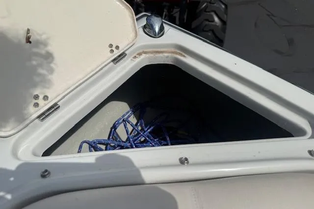 Slide: The Image of Open storage compartment on 2018 Crownline 255 SS boat with blue rope inside. - 35