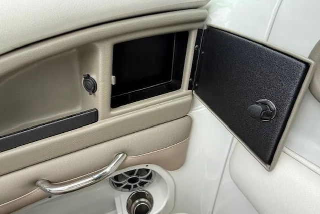 Slide: The Image of 2018 Crownline 255 SS boat interior storage compartment with open door and speaker. - 7