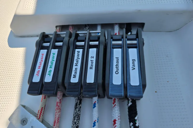 Slide: The Image of Close-up of labeled rope clutches on a 1991 Beneteau 35.5 S5 sailboat. - 22