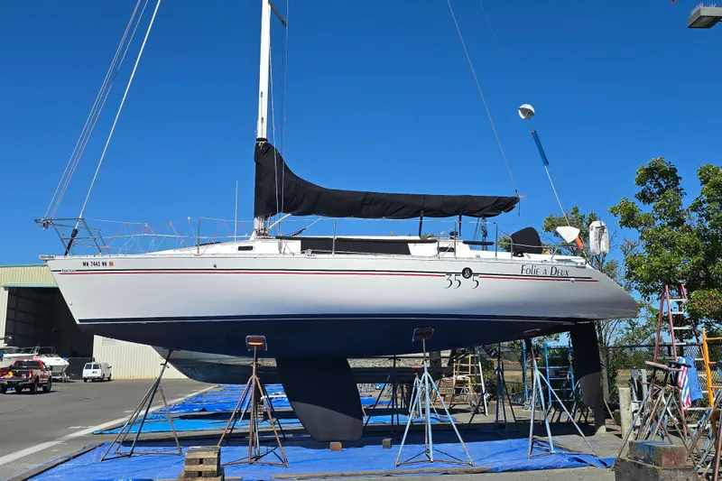 Slide: The Image of 1991 Beneteau 35.5 S5 sailboat on stands, blue sky background. - 26