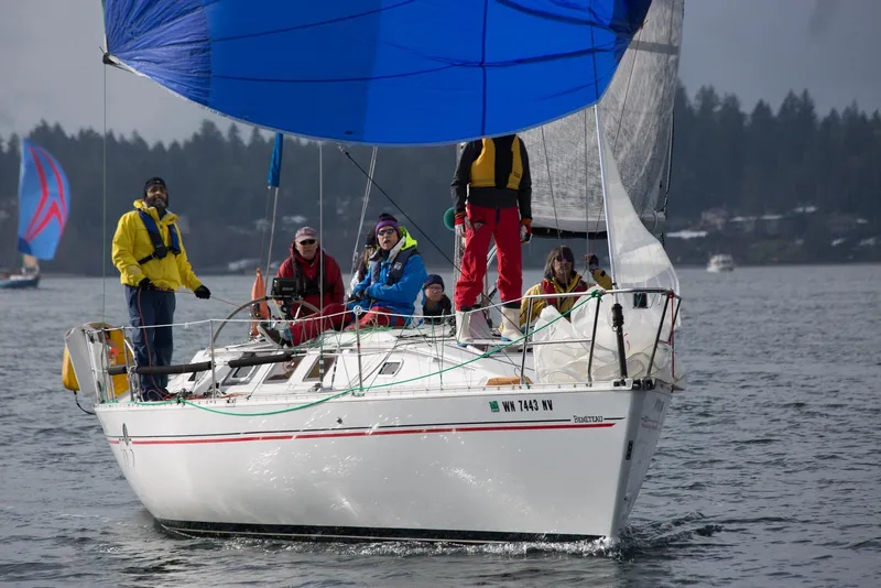 Slide: The Image of Sailboat Beneteau 35.5 S5, 1991 model, with crew sailing on a calm lake. - 3