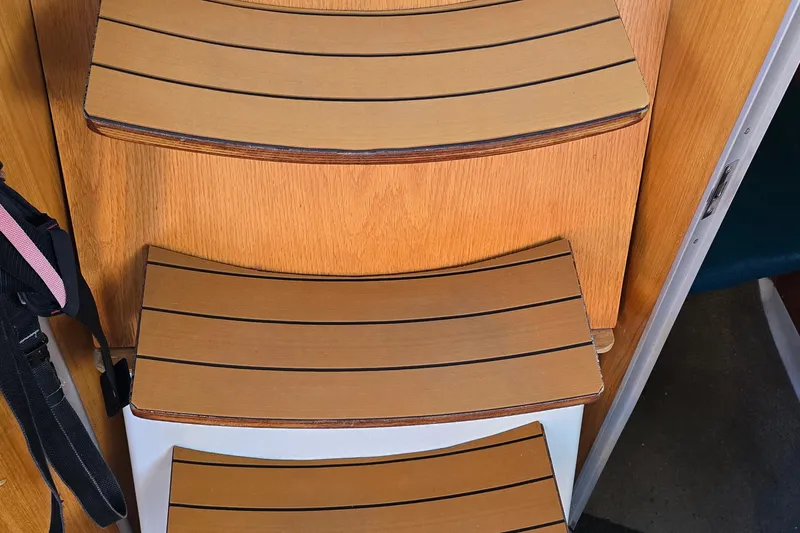 Slide: The Image of Wooden steps inside a 1991 Beneteau 35.5 S5 sailboat, showcasing elegant craftsmanship. - 8