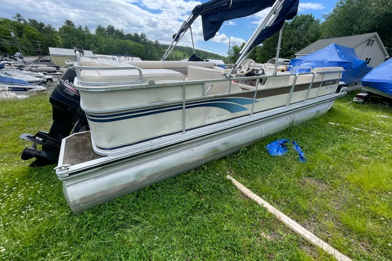 The Image of 1999 Harris Super Sunliner 240 pontoon boat on grass, with blue tarp nearby. - 1