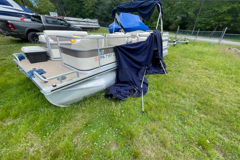 Slide: The Image of 1999 Harris Super Sunliner 240 pontoon boat on grass, partially covered. - 11