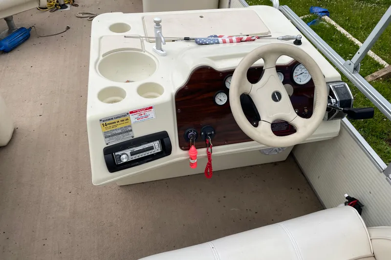 Slide: The Image of 1999 Harris Super Sunliner 240 boat dashboard with steering wheel and control panel. - 5