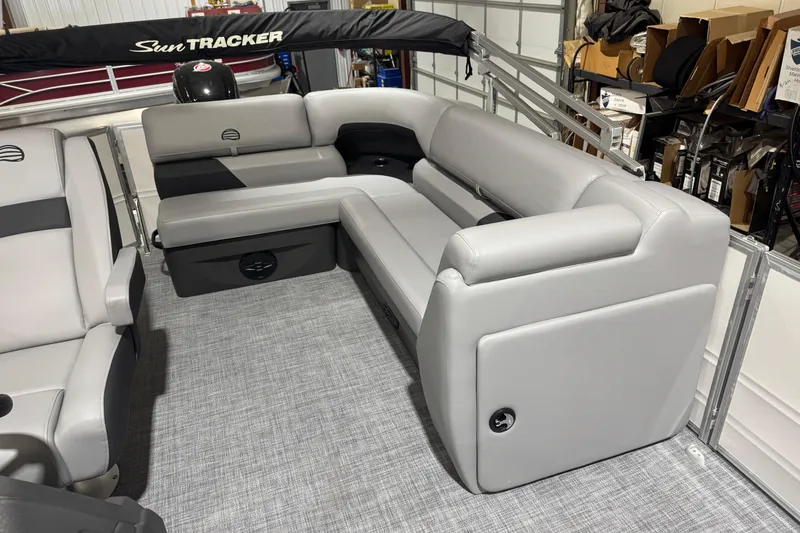 Slide: The Image of 2026 Sun Tracker Party Barge 20 DLX interior with gray seating and storage compartments. - 10