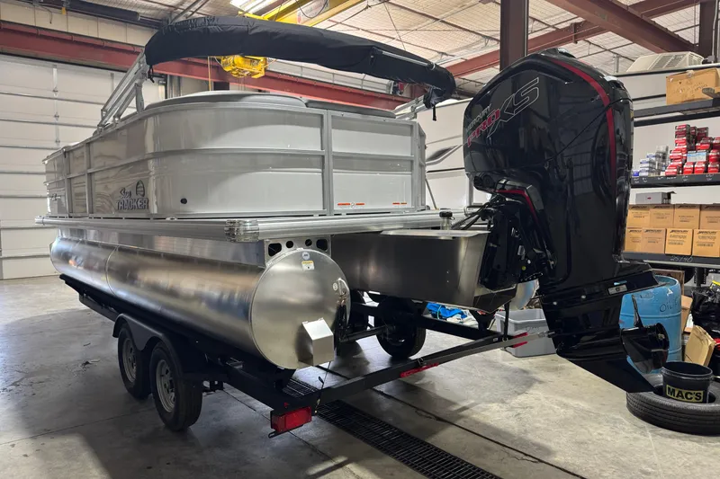 Slide: The Image of 2026 Sun Tracker Party Barge 20 DLX pontoon boat in a garage setting. - 4