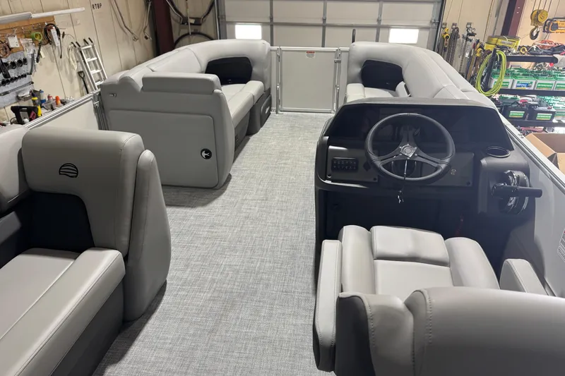 Slide: The Image of 2026 Sun Tracker Party Barge 20 DLX interior with gray seating and steering console. - 7