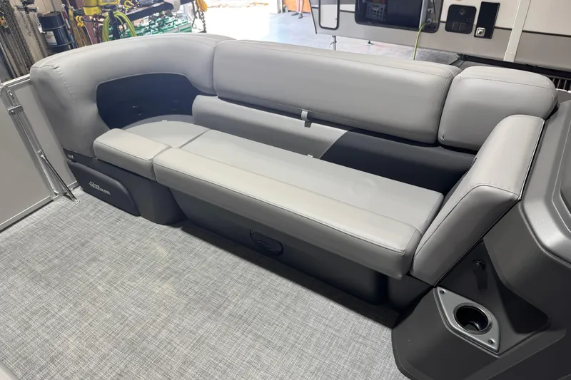 Slide: The Image of 2026 Sun Tracker Party Barge 20 DLX interior seating with gray upholstery and cup holder. - 9