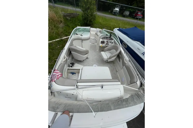 Slide: The Image of 2002 Sea Ray 210 Sundeck boat interior with seating and steering wheel. - 10