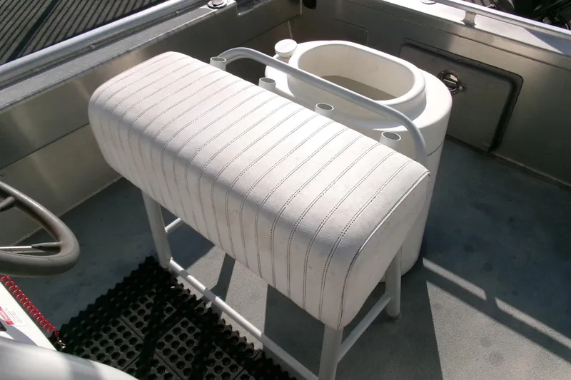 Slide: The Image of White cushioned seat on 2003 Pacific Boats 2025 V, featuring a steering wheel and storage compartment. - 13