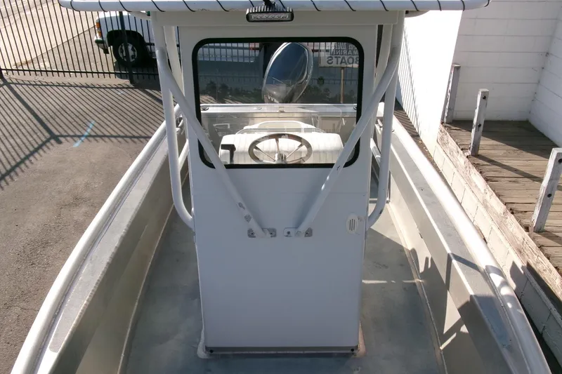 Slide: The Image of 2003 Pacific Boats 2025 V center console, docked, with steering wheel and canopy. - 9