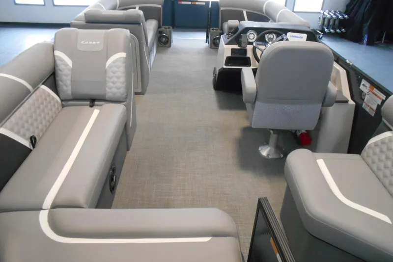 Slide: The Image of 2025 Crest Classic Fish 220 pontoon boat interior with gray seating and modern dashboard. - 13