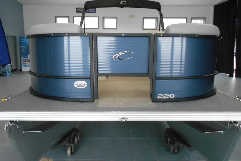 Slide: The Image of 2025 Crest Classic Fish 220 pontoon boat, blue exterior, displayed indoors. - 3