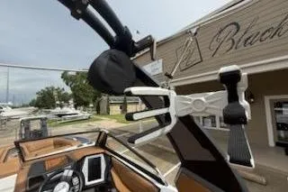 Slide: The Image of 2017 Tigé RZX2 boat interior with wakeboard rack and dashboard, docked near a marina. - 18