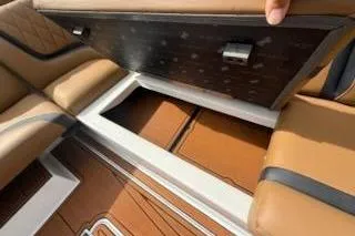 Slide: The Image of 2017 Tigé RZX2 boat interior storage compartment with brown leather seats. - 22