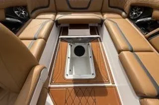 Slide: The Image of 2017 Tigé RZX2 boat interior with tan leather seating and central storage compartment. - 23