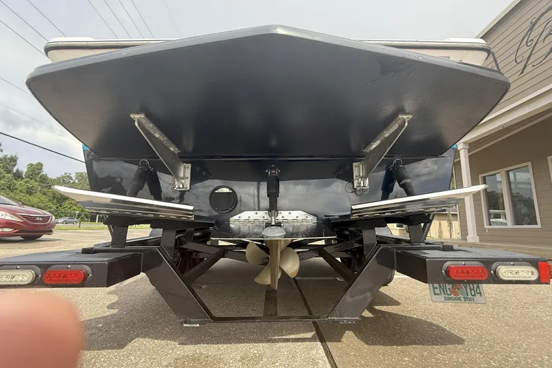 Slide: The Image of Rear view of a 2017 Tigé RZX2 boat on a trailer, showcasing propeller and trim tabs. - 34