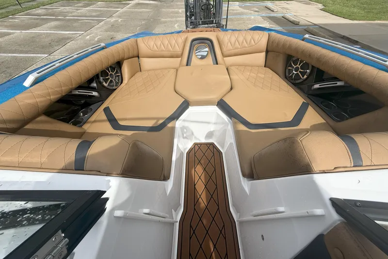 Slide: The Image of 2017 Tigé RZX2 boat interior with tan quilted seating and modern audio system. - 36
