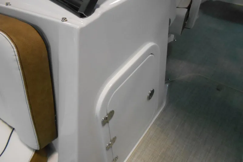 Slide: The Image of 2025 Stingray 201 DC boat interior with white and brown seating and storage compartment. - 17