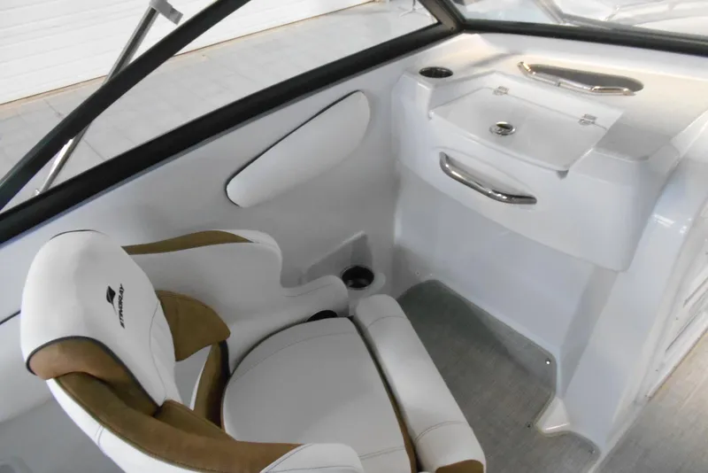 Slide: The Image of 2025 Stingray 201 DC boat interior with white and tan seating, sleek dashboard design. - 18