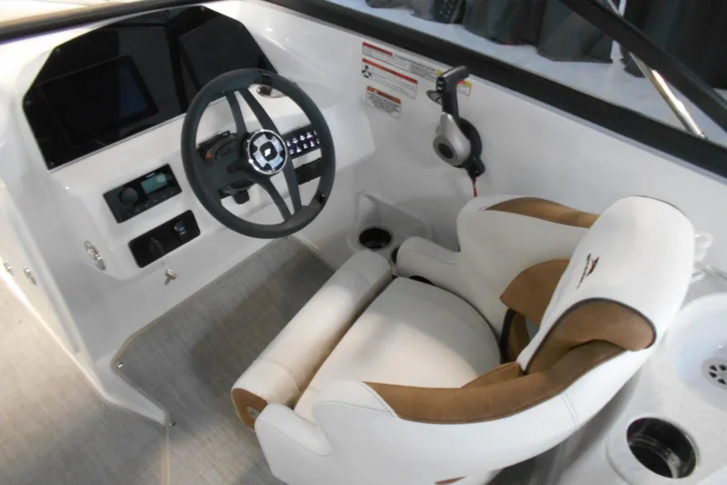 Slide: The Image of 2025 Stingray 201 DC boat interior with steering wheel and comfortable seating. - 19