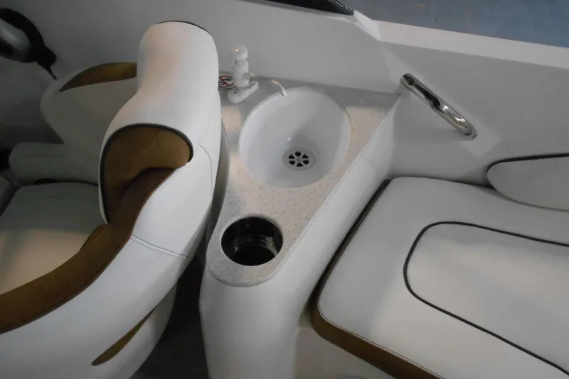 Slide: The Image of 2025 Stingray 201 DC boat interior with white seating, sink, and cup holder. - 20