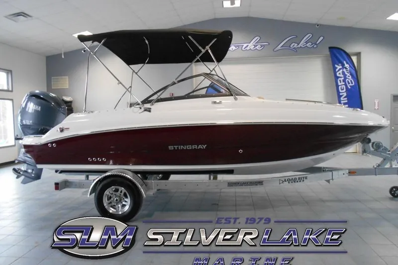 Slide: The Image of 2025 Stingray 201 DC boat displayed indoors at Silver Lake Marine showroom. - 22